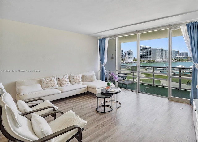 900 Bay Dr Unit 210, Miami Beach, FL 33141 - living room with wood finished floors, a city view, floor to ceiling windows, and a water view