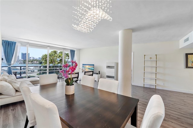 900 Bay Dr Unit 210, Miami Beach, FL 33141 - dining area featuring wood finished floors, expansive windows, a chandelier, and built in shelves