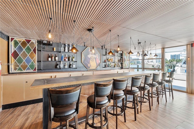 900 Bay Dr Unit 210, Miami Beach, FL 33141 - indoor wet bar featuring light wood-type flooring and hanging light fixtures