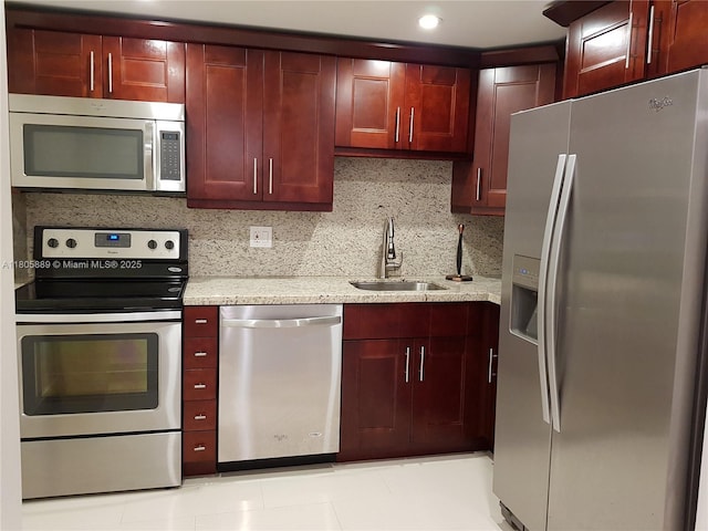 3730 Inverrary Dr Unit 2N, Lauderhill, FL 33319 - kitchen with stainless steel appliances, reddish brown cabinets, a sink, and light stone countertops