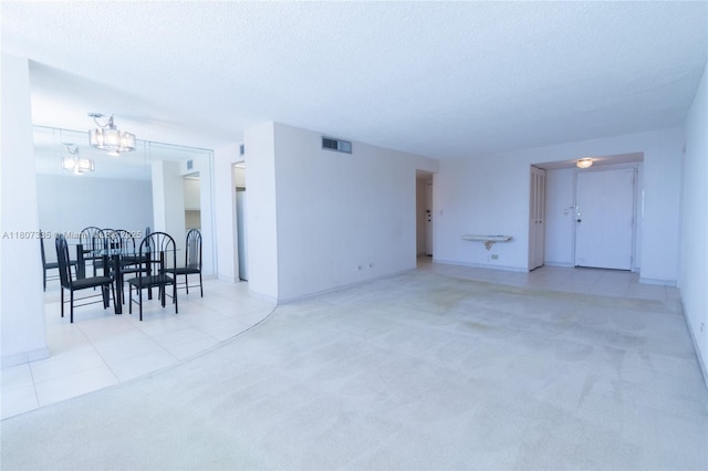 250 174th St Unit 601, Sunny Isles Beach, FL 33160 - unfurnished living room featuring carpet, a chandelier, a textured ceiling, tile patterned floors, and baseboards