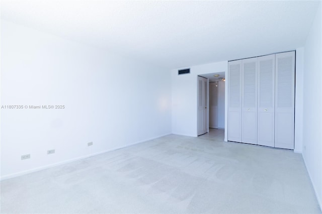 250 174th St Unit 601, Sunny Isles Beach, FL 33160 - unfurnished bedroom with light colored carpet, baseboards, and a closet