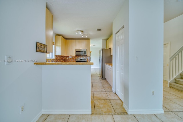 9018 SW 211th Ln, Cutler Bay, FL 33189 - kitchen with appliances with stainless steel finishes, light tile patterned flooring, a peninsula, light countertops, and backsplash
