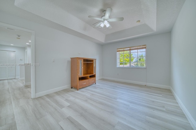 9018 SW 211th Ln, Cutler Bay, FL 33189 - empty room with light wood-style floors, a raised ceiling, ceiling fan, a textured ceiling, and baseboards