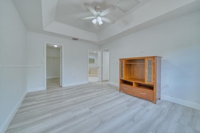 9018 SW 211th Ln, Cutler Bay, FL 33189 - unfurnished bedroom featuring a tray ceiling, light wood-style floors, a walk in closet, and baseboards