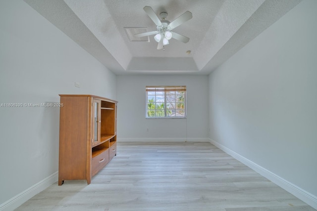 9018 SW 211th Ln, Cutler Bay, FL 33189 - unfurnished bedroom with a tray ceiling, light wood-type flooring, a textured ceiling, baseboards, and ceiling fan