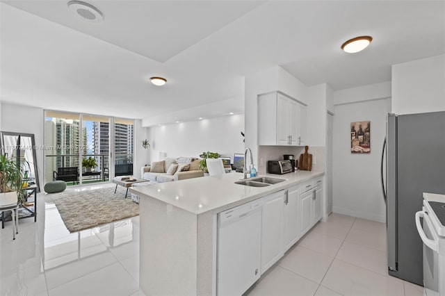 1155 Brickell Bay Dr Unit 2005, Miami, FL 33131 - kitchen with white appliances, a sink, open floor plan, a peninsula, and a wall of windows