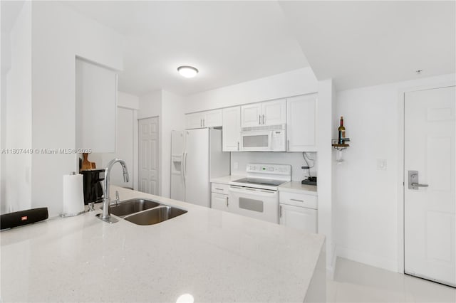 1155 Brickell Bay Dr Unit 2005, Miami, FL 33131 - kitchen with white appliances, a sink, white cabinetry, a peninsula, and baseboards