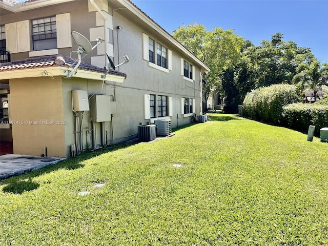 2624 Riverside Dr Unit 2624, Coral Springs, FL 33065 - view of side of property featuring stucco siding, a lawn, and central air condition unit