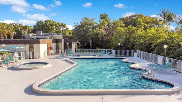19412 NE 26th Ave Unit 143B, Miami, FL 33180 - community pool with a patio area, a hot tub, and view of wooded area