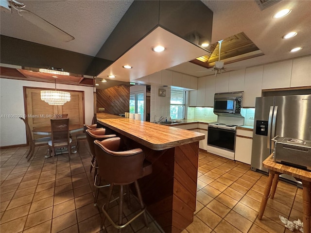 2040 N Hibiscus Dr, North Miami, FL 33181 - kitchen featuring white electric range oven, stainless steel refrigerator with ice dispenser, a sink, a peninsula, and wooden counters