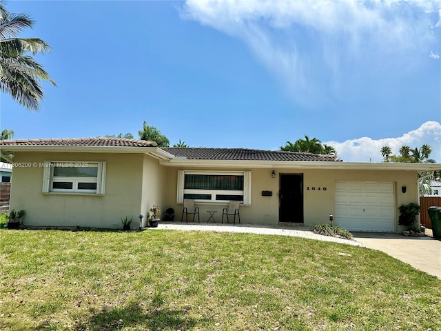 2040 N Hibiscus Dr, North Miami, FL 33181 - ranch-style home with a garage, stucco siding, a tiled roof, a front yard, and driveway