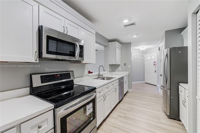 133 NW 98th Ter, Plantation, FL 33324 - kitchen featuring stainless steel appliances, a sink, white cabinets, and light countertops