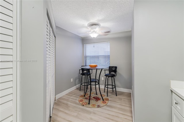 133 NW 98th Ter, Plantation, FL 33324 - dining area with a textured ceiling, light wood-type flooring, a ceiling fan, and baseboards