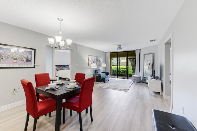 133 NW 98th Ter, Plantation, FL 33324 - dining space featuring light wood-style flooring, a textured ceiling, ceiling fan, a wall of windows, and a chandelier