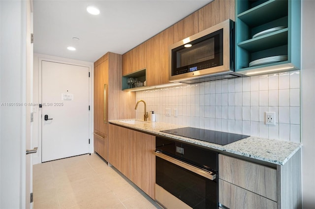 601 NE 1st Ave Unit 3507, Miami, FL 33132 - kitchen with oven, stainless steel microwave, open shelves, black electric stovetop, and a sink