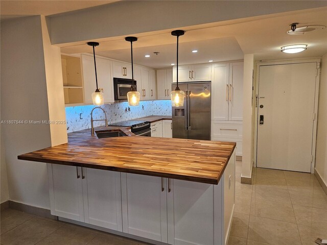 2625 Collins Ave Unit 1408, Miami Beach, FL 33140 - kitchen with appliances with stainless steel finishes, butcher block countertops, a sink, light tile patterned floors, and recessed lighting