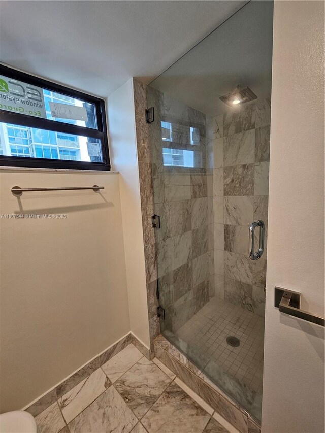2625 Collins Ave Unit 1408, Miami Beach, FL 33140 - bathroom with baseboards, a shower stall, and marble look tiles