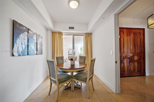 5235 Fisher Island Dr Unit 5235, Miami Beach, FL 33109 - dining area featuring a tray ceiling, baseboards, and light tile patterned flooring