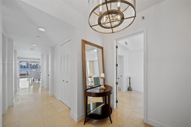 5235 Fisher Island Dr Unit 5235, Miami Beach, FL 33109 - corridor featuring light tile patterned floors, a chandelier, and baseboards