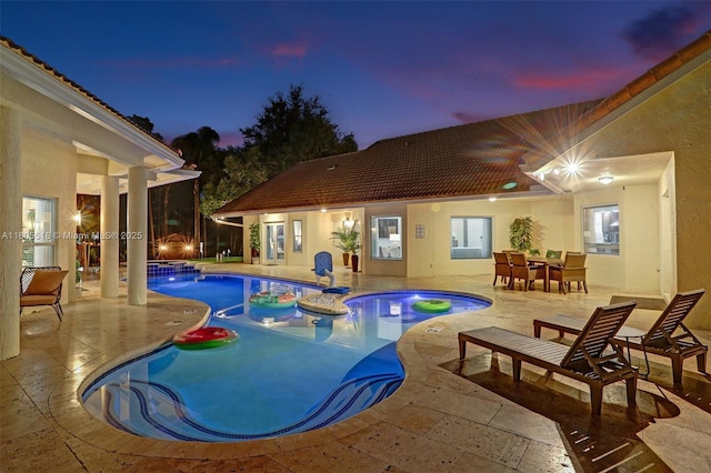 16301 SW 62nd St, Southwest Ranches, FL 33331 - pool at dusk with a patio, a pool with connected hot tub, and outdoor dining space