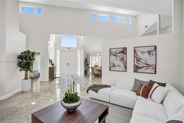 16301 SW 62nd St, Southwest Ranches, FL 33331 - living room featuring marble tiled flooring, a towering ceiling, a chandelier, and baseboards