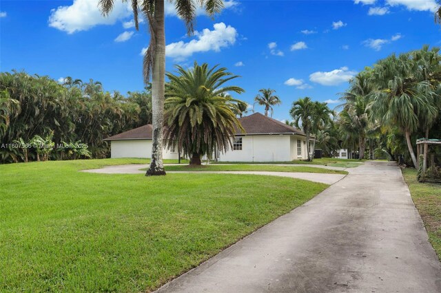 5310 SW 172nd Ave, Southwest Ranches, FL 33331 - obstructed view of property featuring a front lawn, curved driveway, and stucco siding