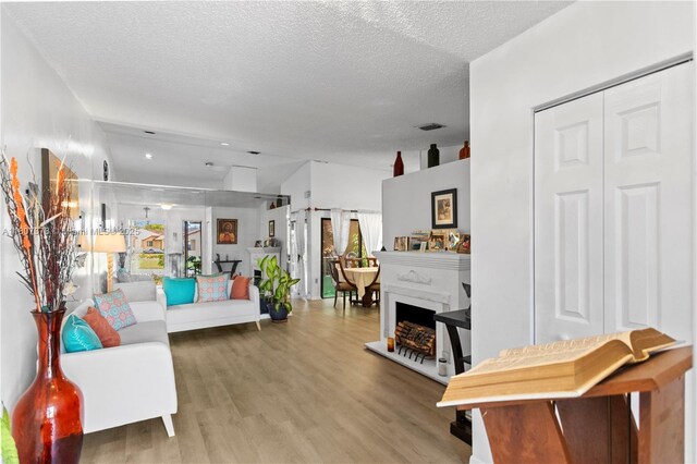 17320 NW 66th Pl, Hialeah, FL 33015 - living room featuring wood finished floors, a textured ceiling, and a fireplace