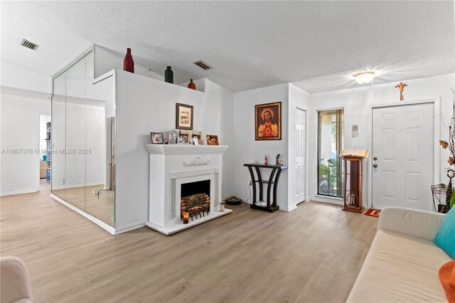 17320 NW 66th Pl, Hialeah, FL 33015 - living area featuring wood finished floors, a textured ceiling, baseboards, a fireplace with raised hearth, and lofted ceiling