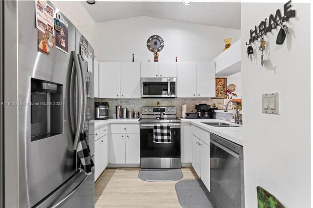 17320 NW 66th Pl, Hialeah, FL 33015 - kitchen featuring appliances with stainless steel finishes, a sink, tasteful backsplash, light countertops, and lofted ceiling