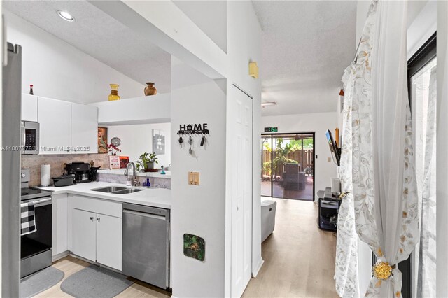 17320 NW 66th Pl, Hialeah, FL 33015 - kitchen with stainless steel appliances, a sink, decorative backsplash, light wood-style floors, and white cabinetry
