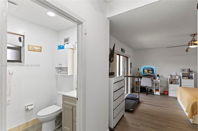 17320 NW 66th Pl, Hialeah, FL 33015 - bathroom with wood finished floors, toilet, a textured ceiling, ceiling fan, and baseboards