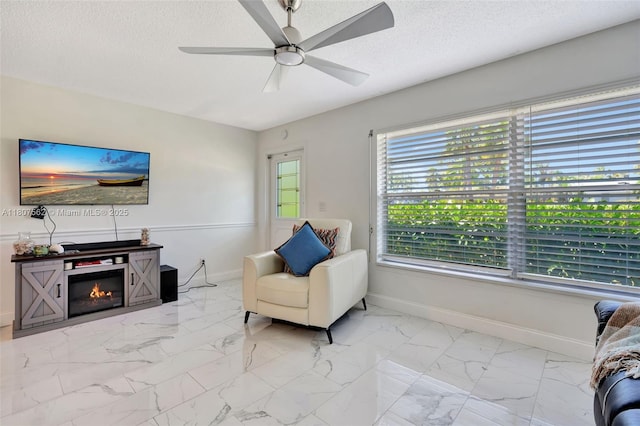 2929 SE Ocean Blvd Unit 123-2, Stuart, FL 34996 - sitting room featuring a ceiling fan, baseboards, marble look tile flooring, and a textured ceiling