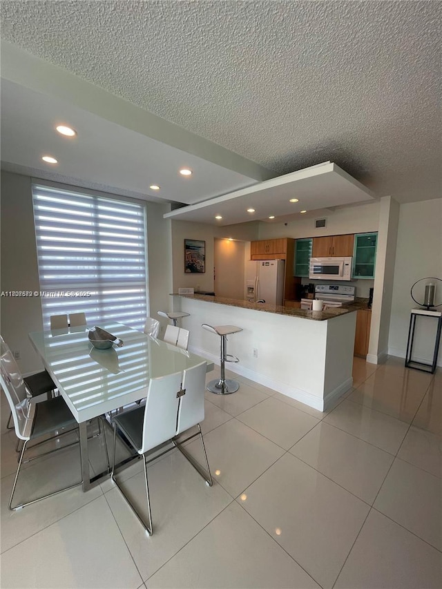 17555 Atlantic Blvd Unit 702, Sunny Isles Beach, FL 33160 - dining space with a textured ceiling, recessed lighting, light tile patterned floors, and baseboards