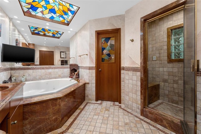 5725 N Bayshore Dr, Miami, FL 33137 - bathroom with tile walls, a tub with jets, vanity, a shower stall, and recessed lighting