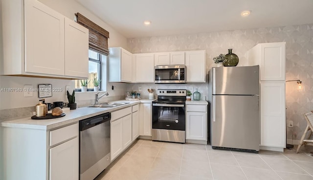1497 NE 3rd Ave, Florida City, FL 33034 - kitchen with appliances with stainless steel finishes, a sink, wallpapered walls, light countertops, and white cabinets