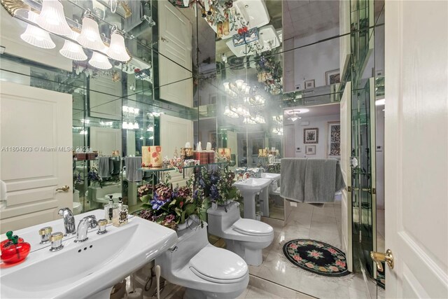 8925 Collins Ave Unit 4A, Surfside, FL 33154 - bathroom featuring toilet, a sink, marble finish flooring, and a chandelier