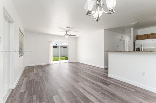 1402 E River Dr, Margate, FL 33063 - unfurnished living room featuring wood finished floors, ceiling fan, a chandelier, and baseboards