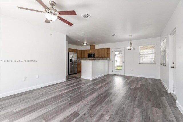 1402 E River Dr, Margate, FL 33063 - unfurnished living room featuring ceiling fan, a chandelier, dark wood-type flooring, and baseboards