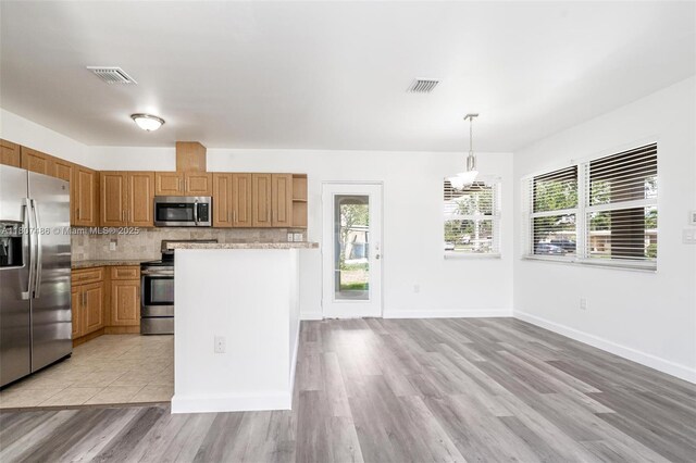 1402 E River Dr, Margate, FL 33063 - kitchen with appliances with stainless steel finishes, open shelves, decorative backsplash, and plenty of natural light
