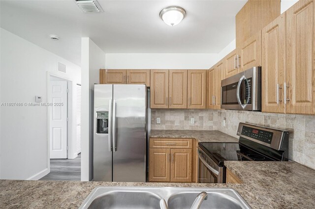 1402 E River Dr, Margate, FL 33063 - kitchen featuring appliances with stainless steel finishes, decorative backsplash, wood finished floors, and a sink