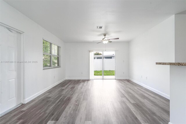 1402 E River Dr, Margate, FL 33063 - empty room with healthy amount of natural light, wood finished floors, and ceiling fan