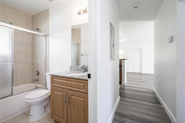 1402 E River Dr, Margate, FL 33063 - full bath with bath / shower combo with glass door, toilet, vanity, wood finished floors, and baseboards