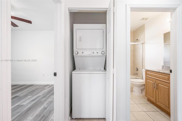 1402 E River Dr, Margate, FL 33063 - laundry room featuring stacked washer and clothes dryer, ceiling fan, and light tile patterned flooring