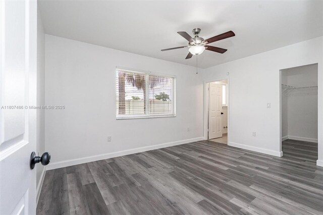 1402 E River Dr, Margate, FL 33063 - unfurnished bedroom featuring wood finished floors, baseboards, a walk in closet, a ceiling fan, and a closet