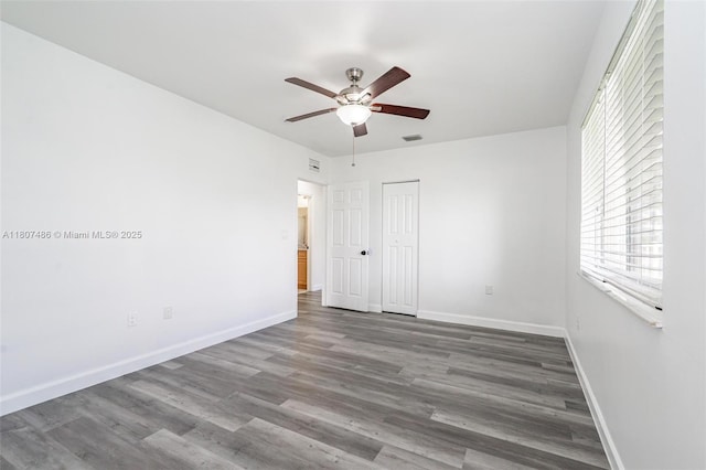 1402 E River Dr, Margate, FL 33063 - unfurnished bedroom featuring wood finished floors, baseboards, multiple windows, and a closet