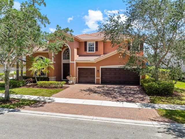 19165 N Gardenia Ave, Weston, FL 33332 - mediterranean / spanish home featuring a tiled roof, decorative driveway, stucco siding, and a garage
