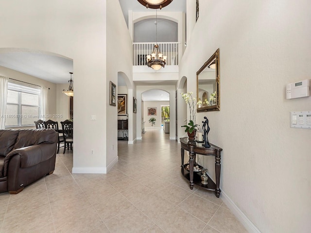 19165 N Gardenia Ave, Weston, FL 33332 - entryway featuring arched walkways, a chandelier, baseboards, light tile patterned floors, and a high ceiling
