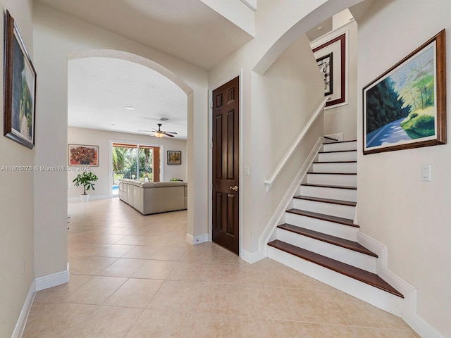 19165 N Gardenia Ave, Weston, FL 33332 - staircase with arched walkways, a ceiling fan, tile patterned floors, and baseboards