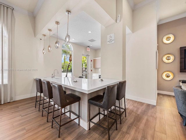 19165 N Gardenia Ave, Weston, FL 33332 - kitchen featuring wood finished floors, baseboards, a breakfast bar, ornamental molding, and recessed lighting